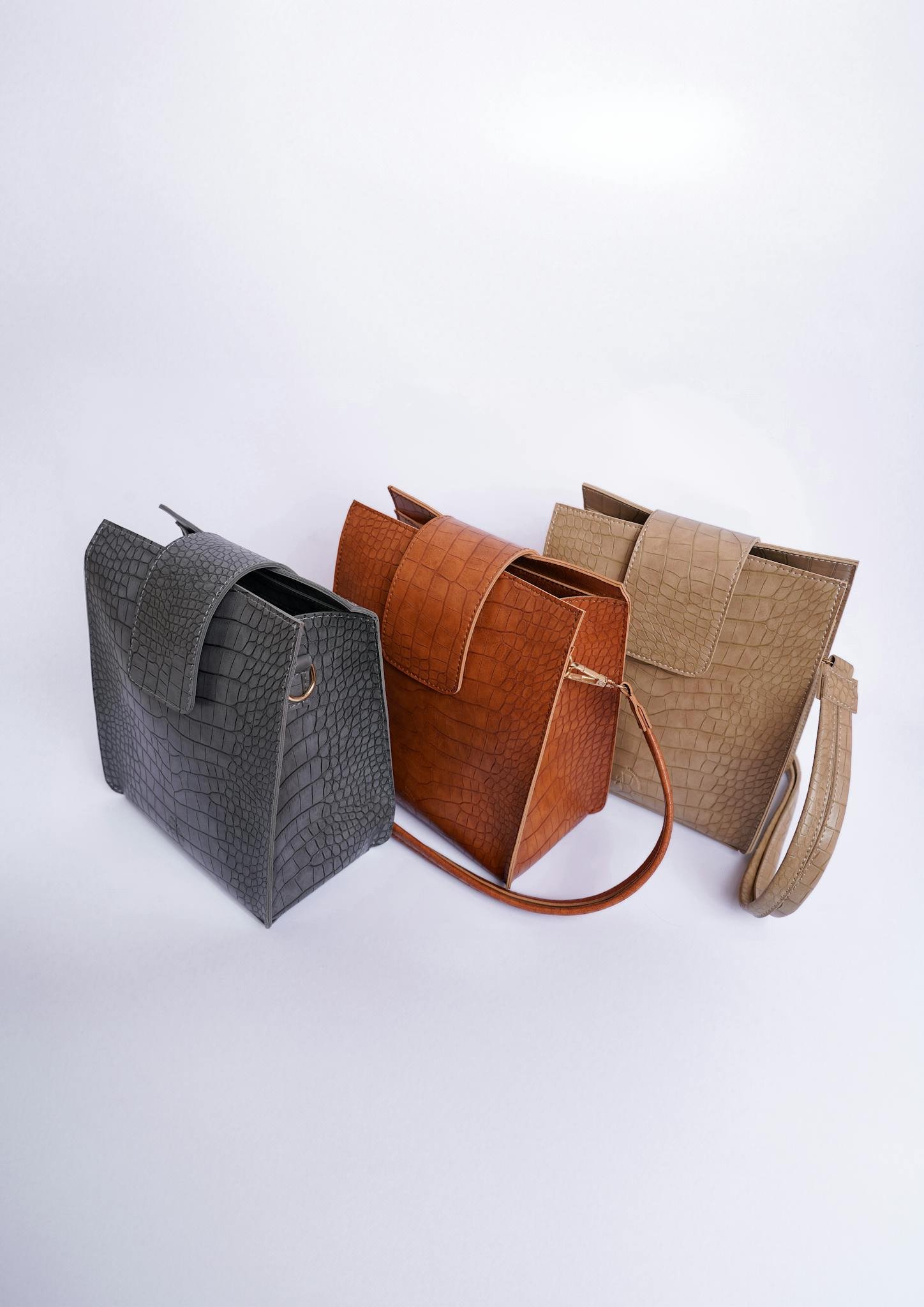 A stylish arrangement of three leather bags on a white background, perfect for fashion and accessory themes.